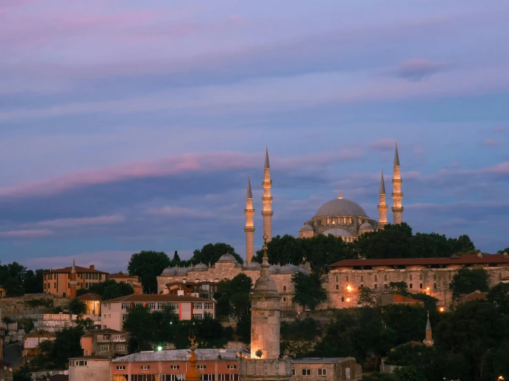 a mosque with towers lit up in the evening