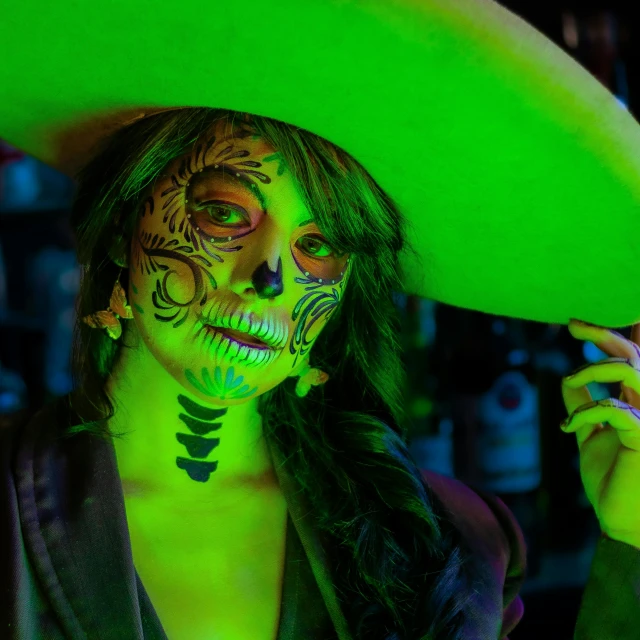 woman in neon makeup and face paint poses for the camera