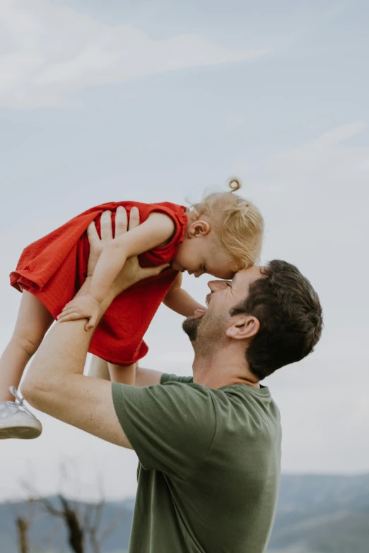 a man is holding his small child in the air