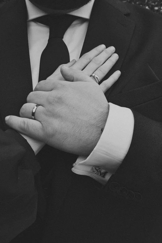 a man wearing a suit and ring that is on his left wrist