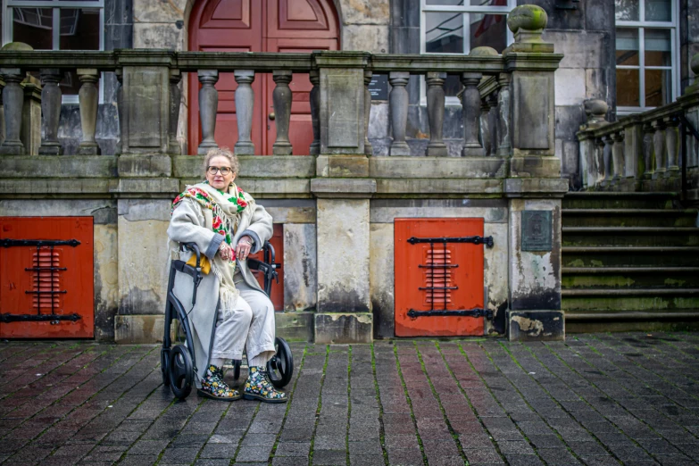 an old lady riding a bike on the cobblestones