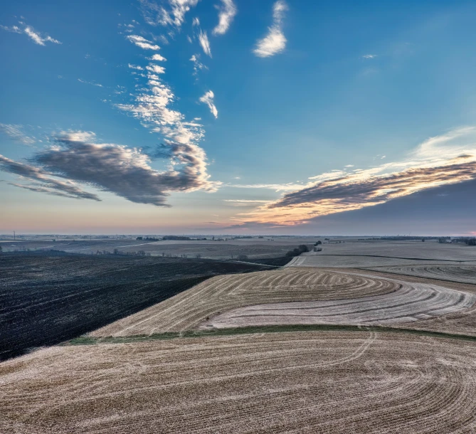 a landscape with clouds and trees in the distance