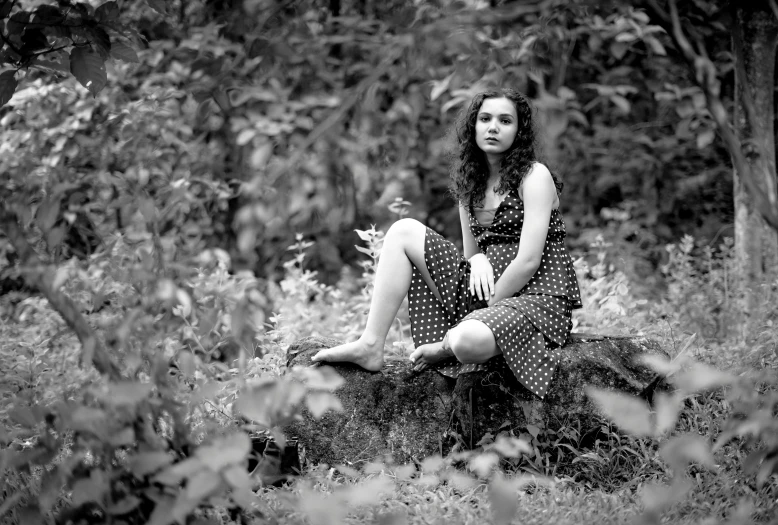 black and white pograph of a girl sitting in the grass