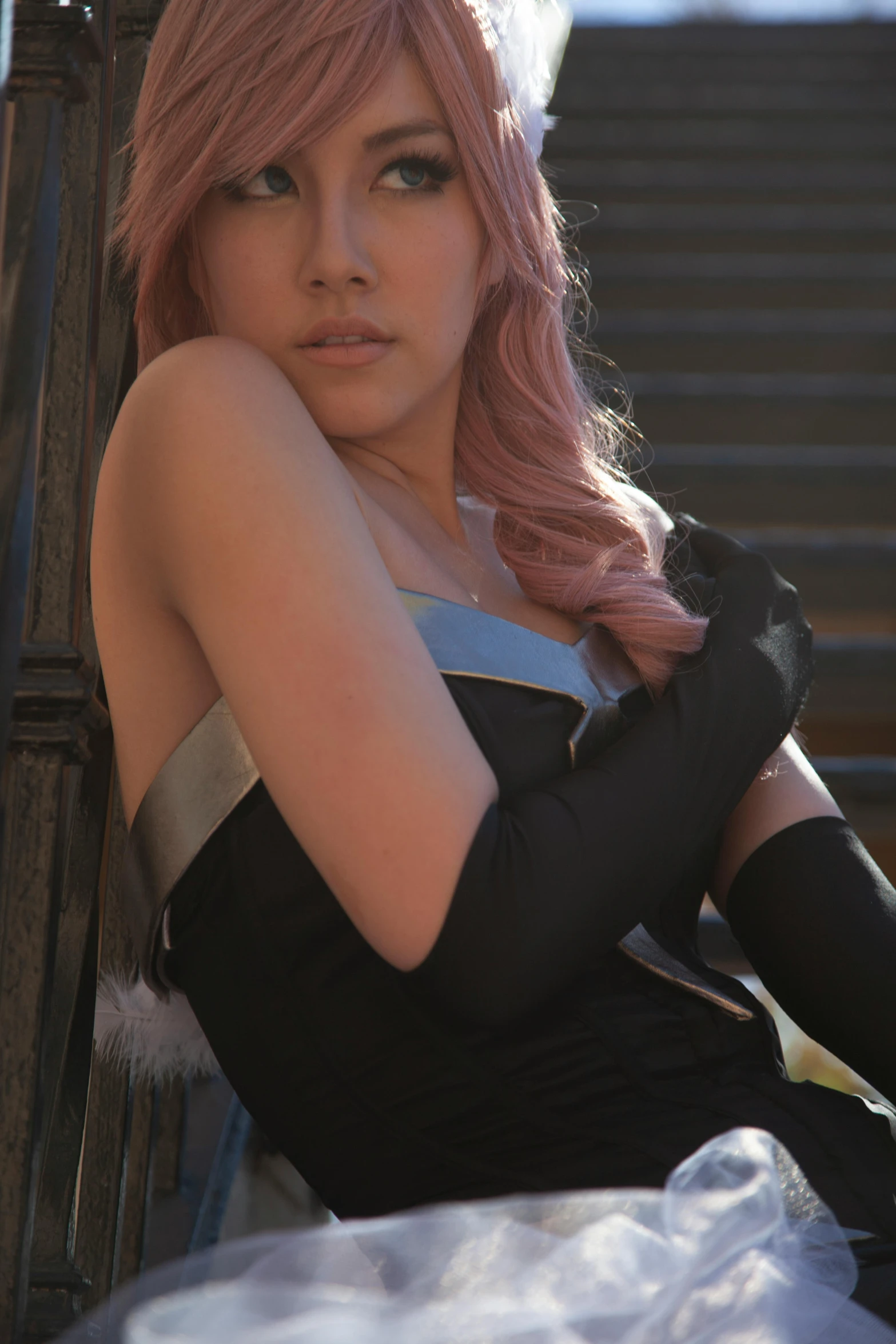 a woman with pink hair posing with her arms leaning on her chest