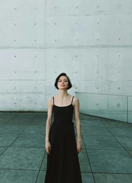 a woman standing with her eyes closed in the background