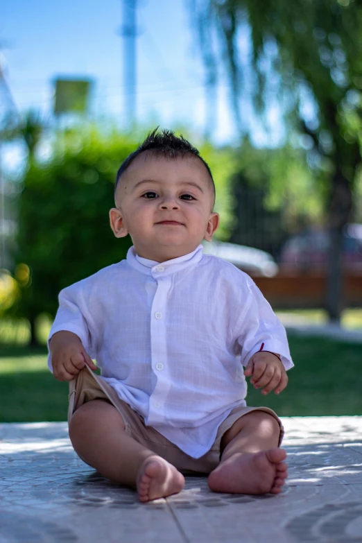 a baby is sitting on the ground and holding a paper plate