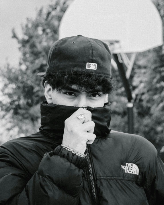 a man poses wearing his face in front of trees