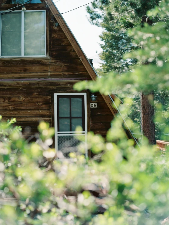 a wooden house is seen through the trees