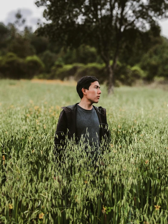 a man standing in a field looking up at soing