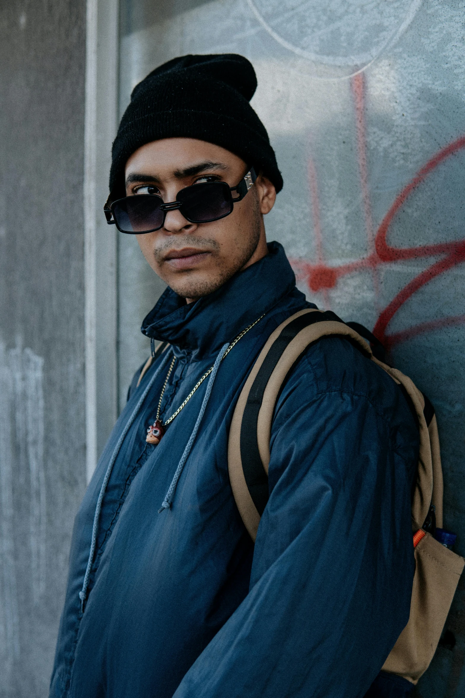 a man standing in front of a graffiti covered wall