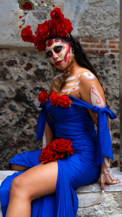 a woman in a blue dress with skulls on her face