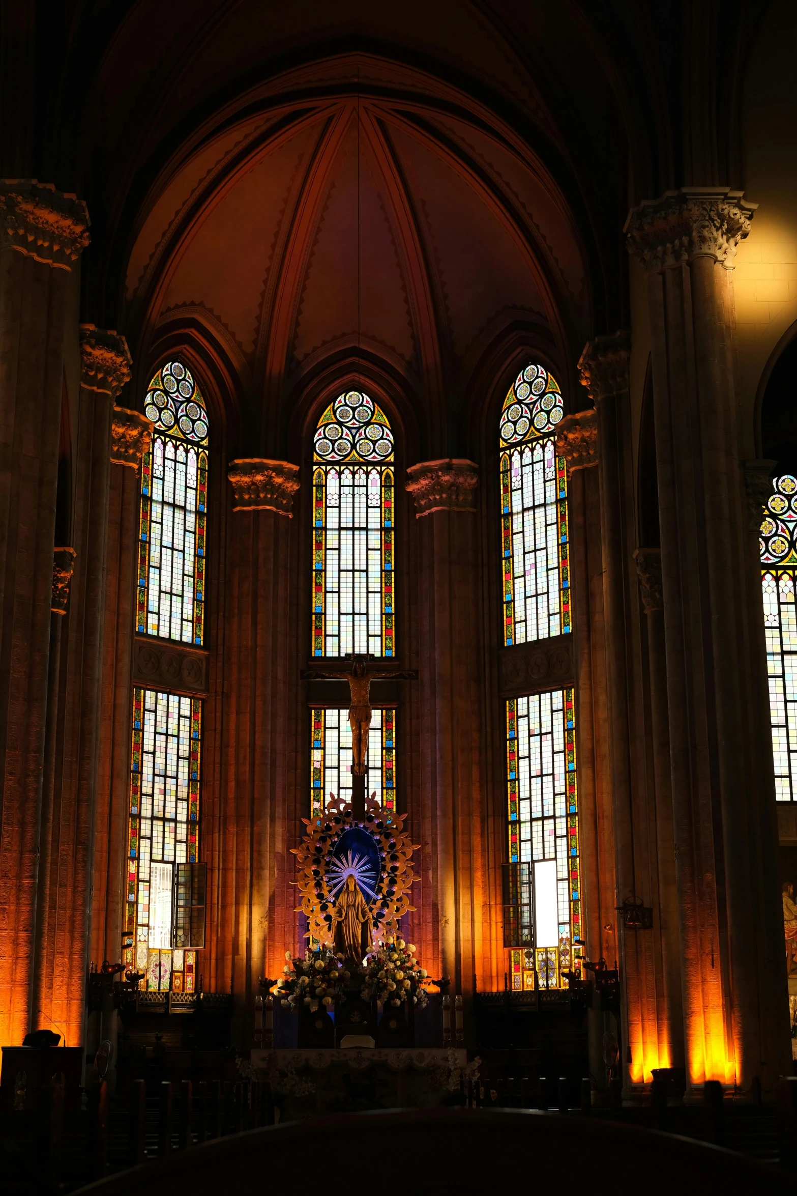 an elaborate church decorated in dark tones with a cross