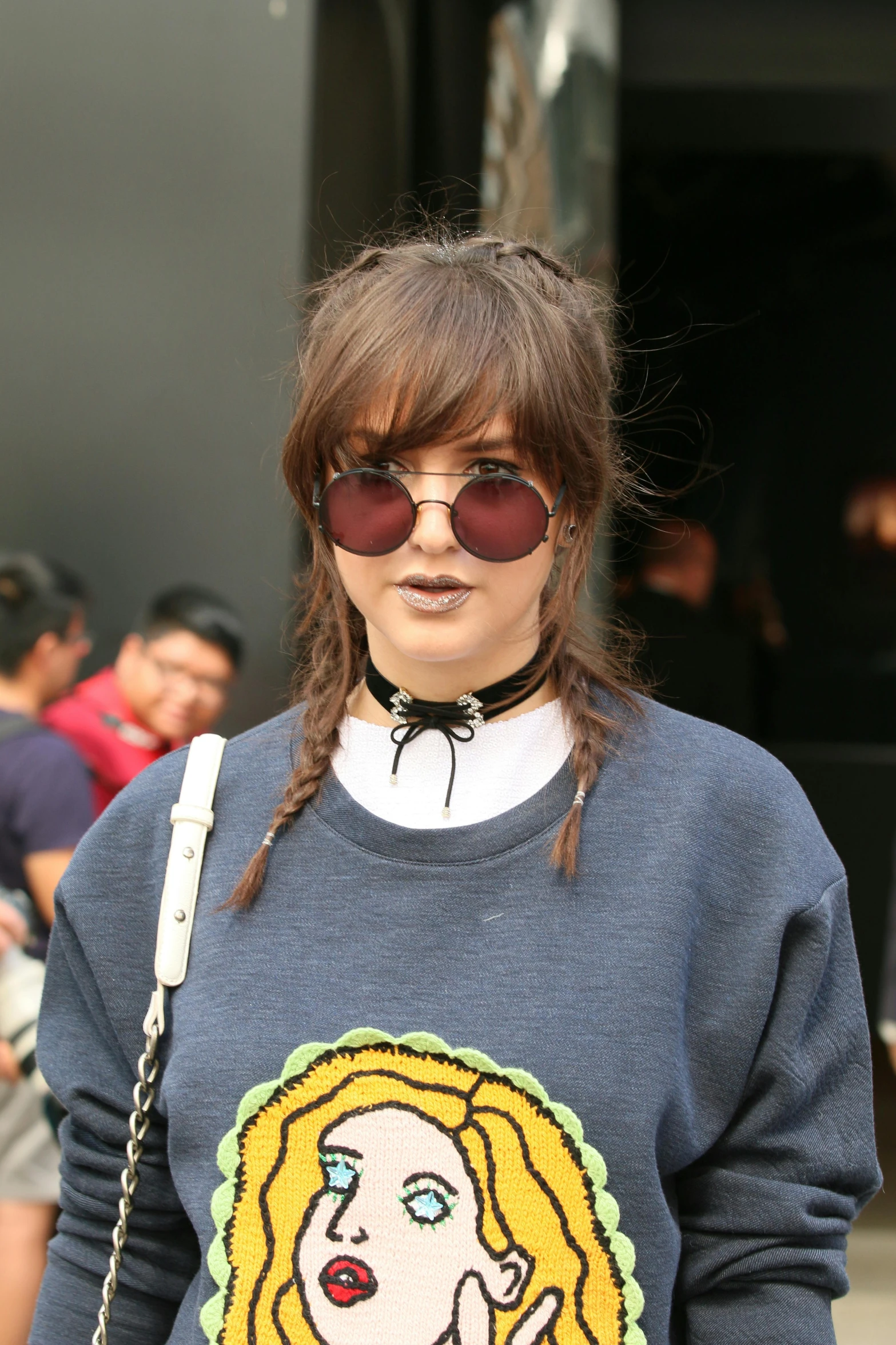 a woman wearing sunglasses and a blue sweater