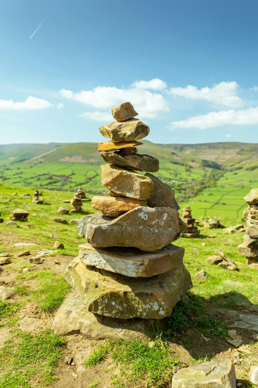 a pile of rocks on a hillside with a sky background