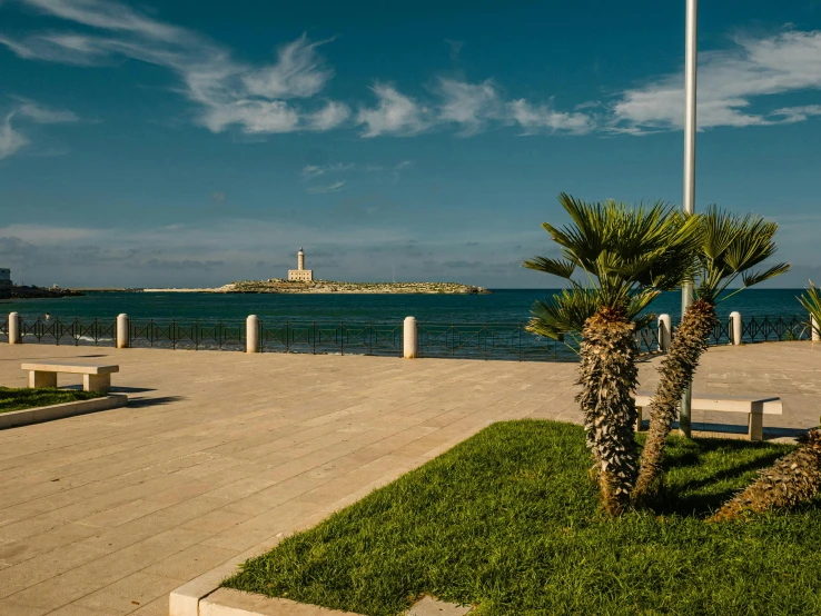 a flag flying over the ocean near a path