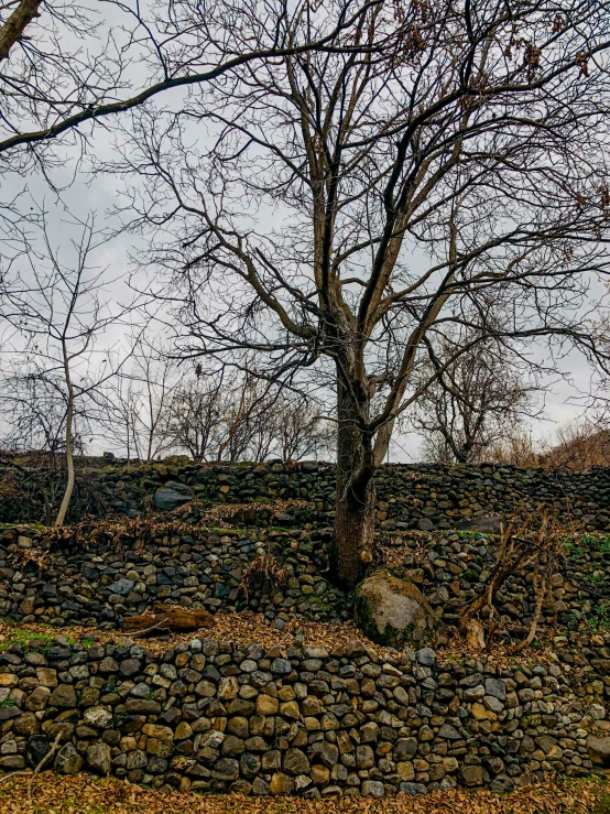 a stone wall in the middle of an open field