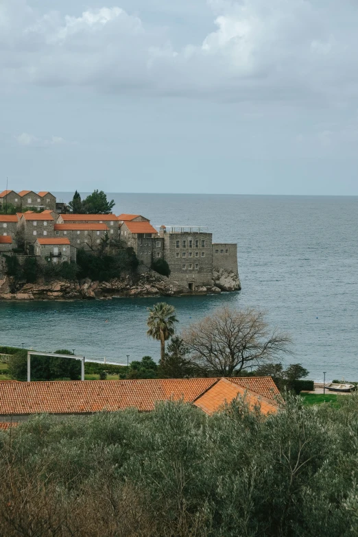 a view of the ocean, buildings, and some hills