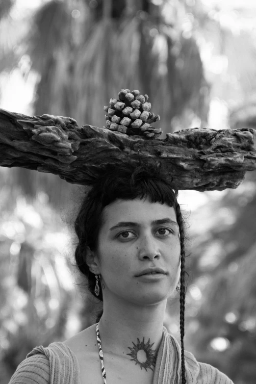 a woman standing in front of a cross in the forest