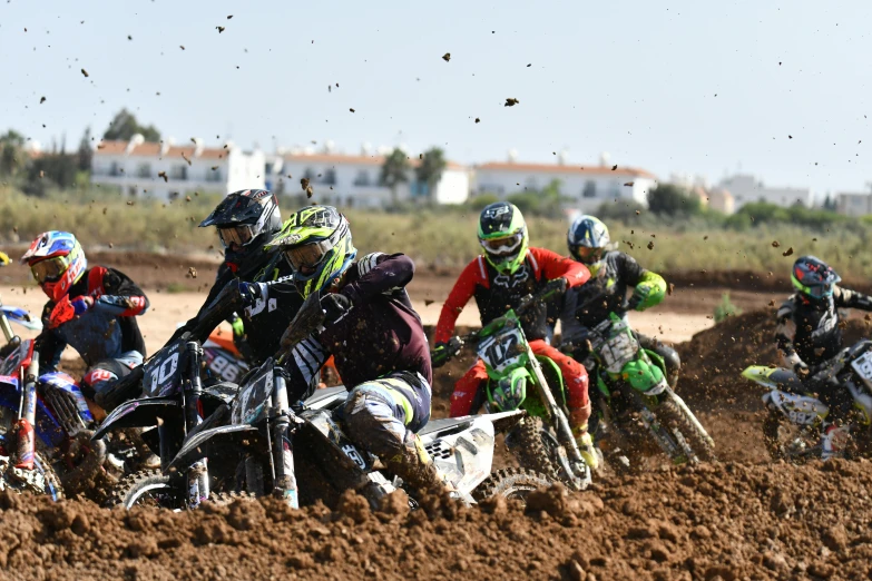 several people riding motorcycles in the mud