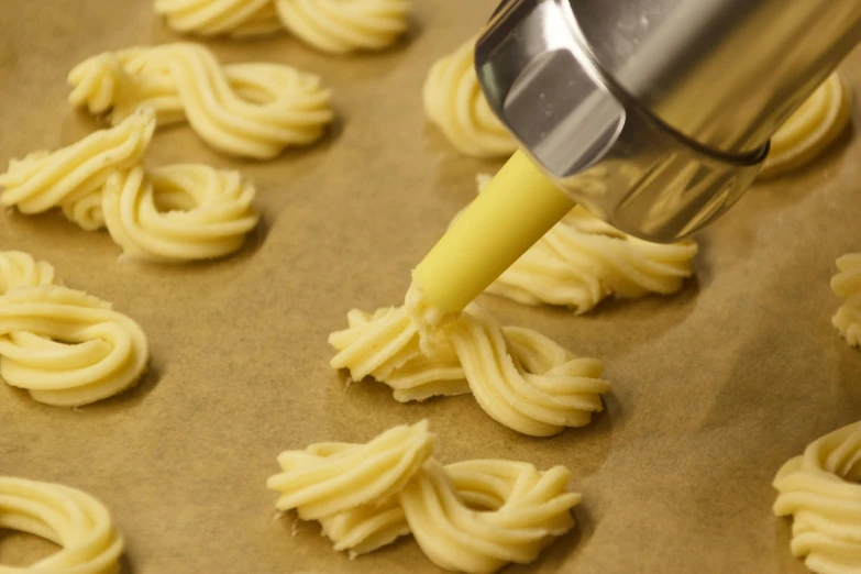 a hand is mixing yellow sauce over noodles