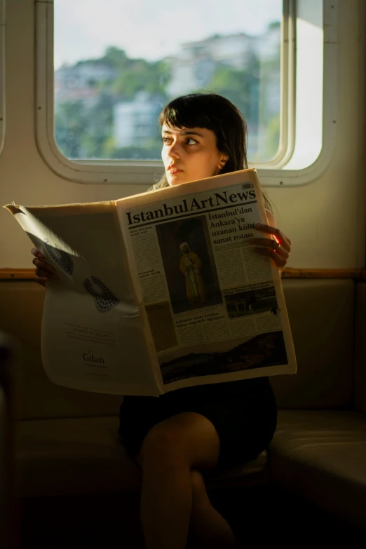 woman holding newspaper with window in urban area