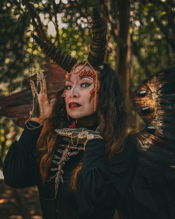 woman with angelic makeup and hair, wearing a devil costume