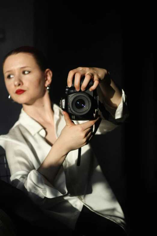 a woman taking a self portrait with a black camera