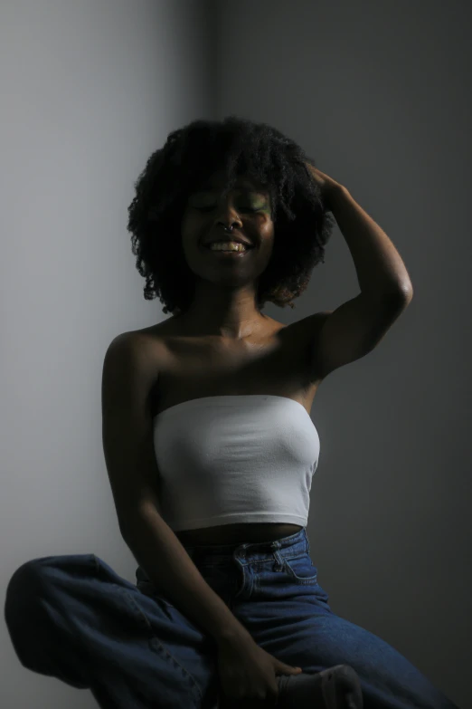 a black woman sitting down with her foot on the wall