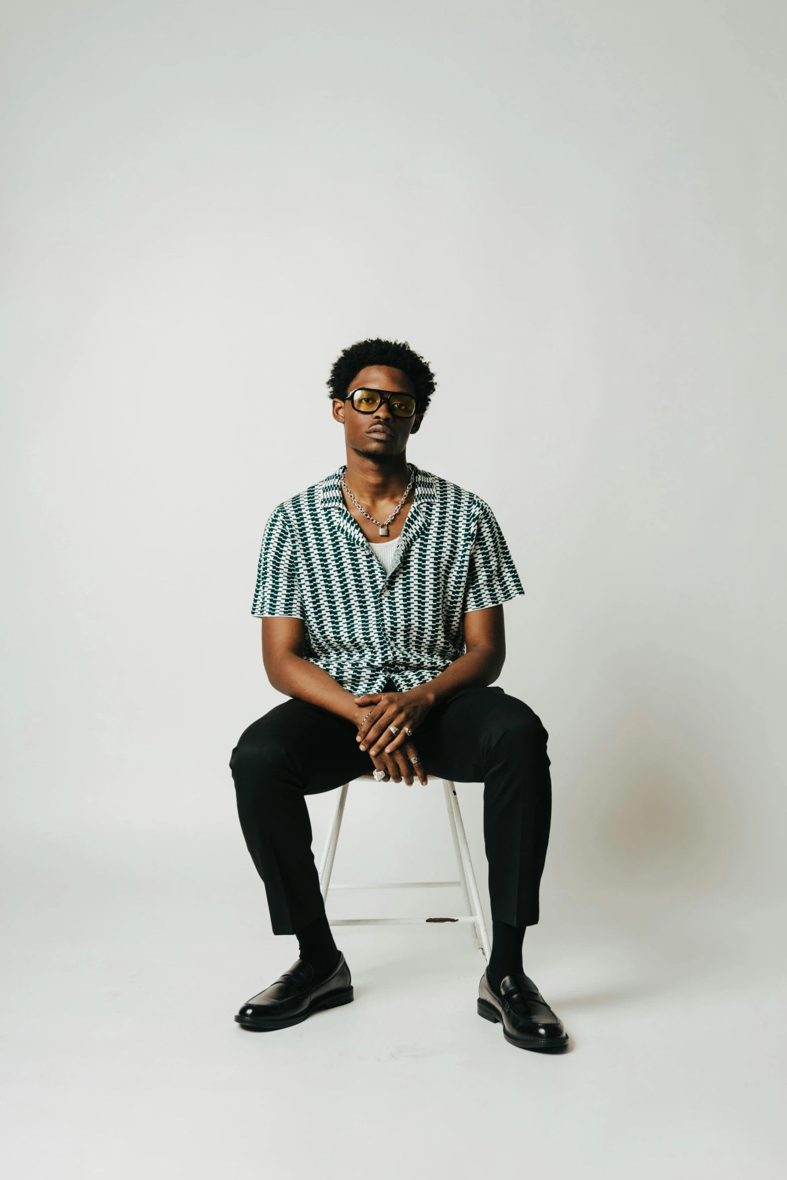 a man sitting on a chair wearing glasses