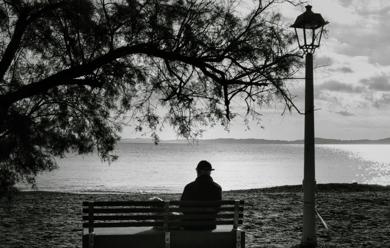 black and white po of person sitting on bench