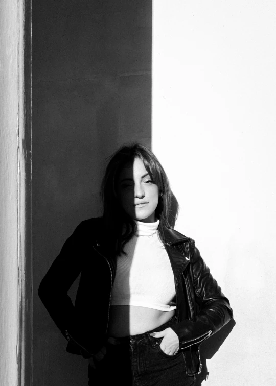 black and white po of a woman standing with her arms crossed