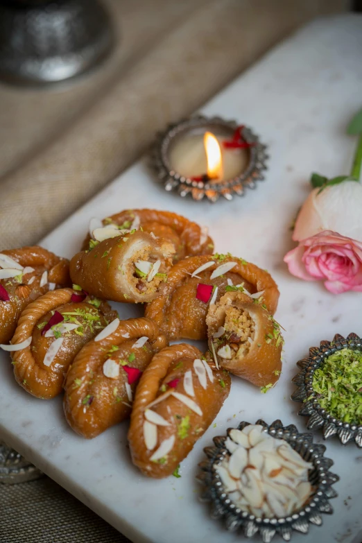 a plate of assorted pastries in front of a lit candle