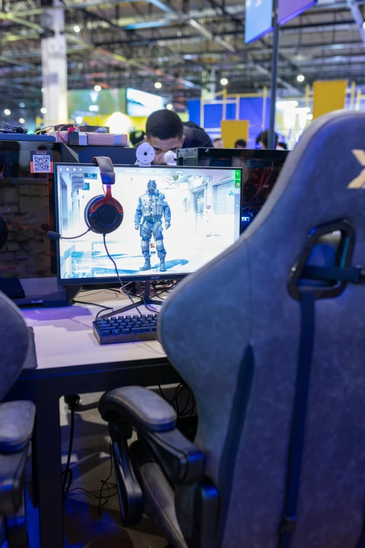 some chairs around a desk with two computer screens on it