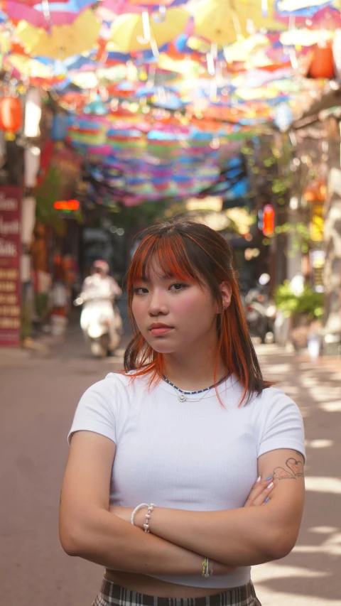 a woman standing with her arms crossed in an asian street