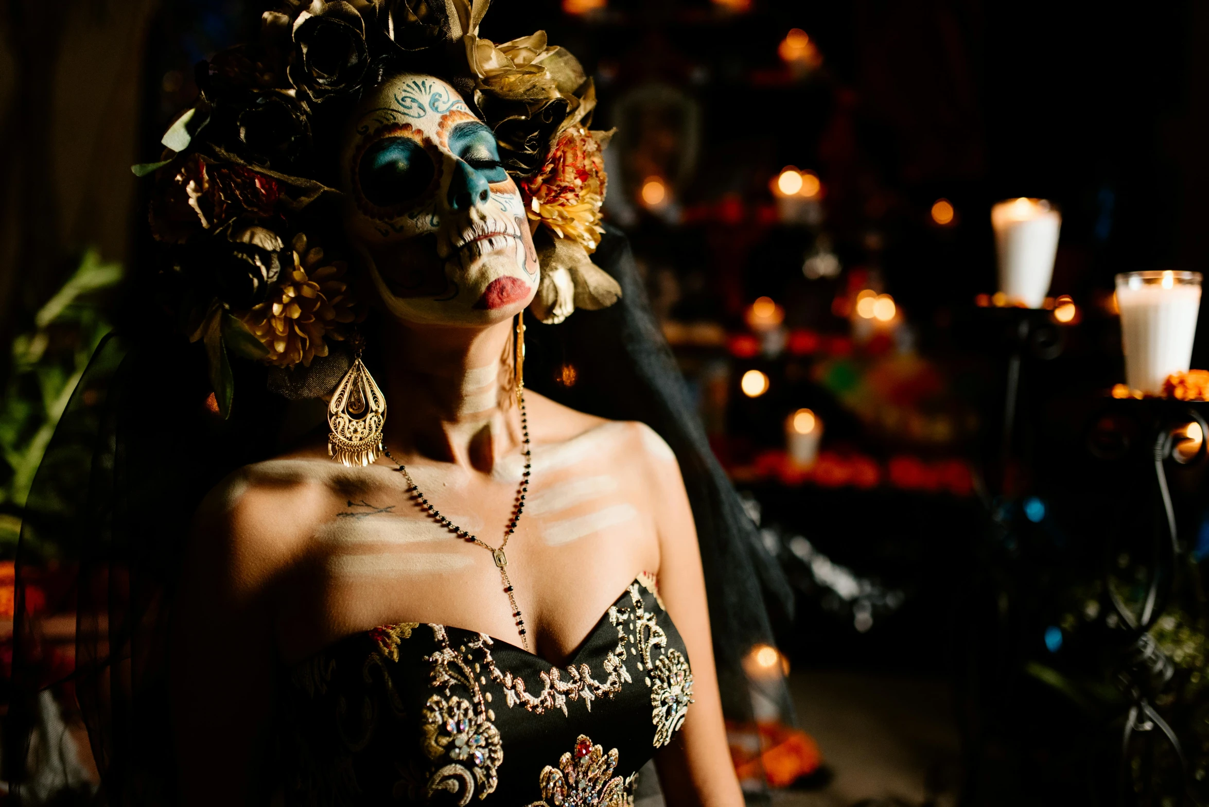 a woman is posing in an elaborate costume with flowers and candles