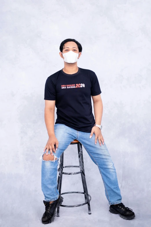 a man wearing a mask poses with a chair