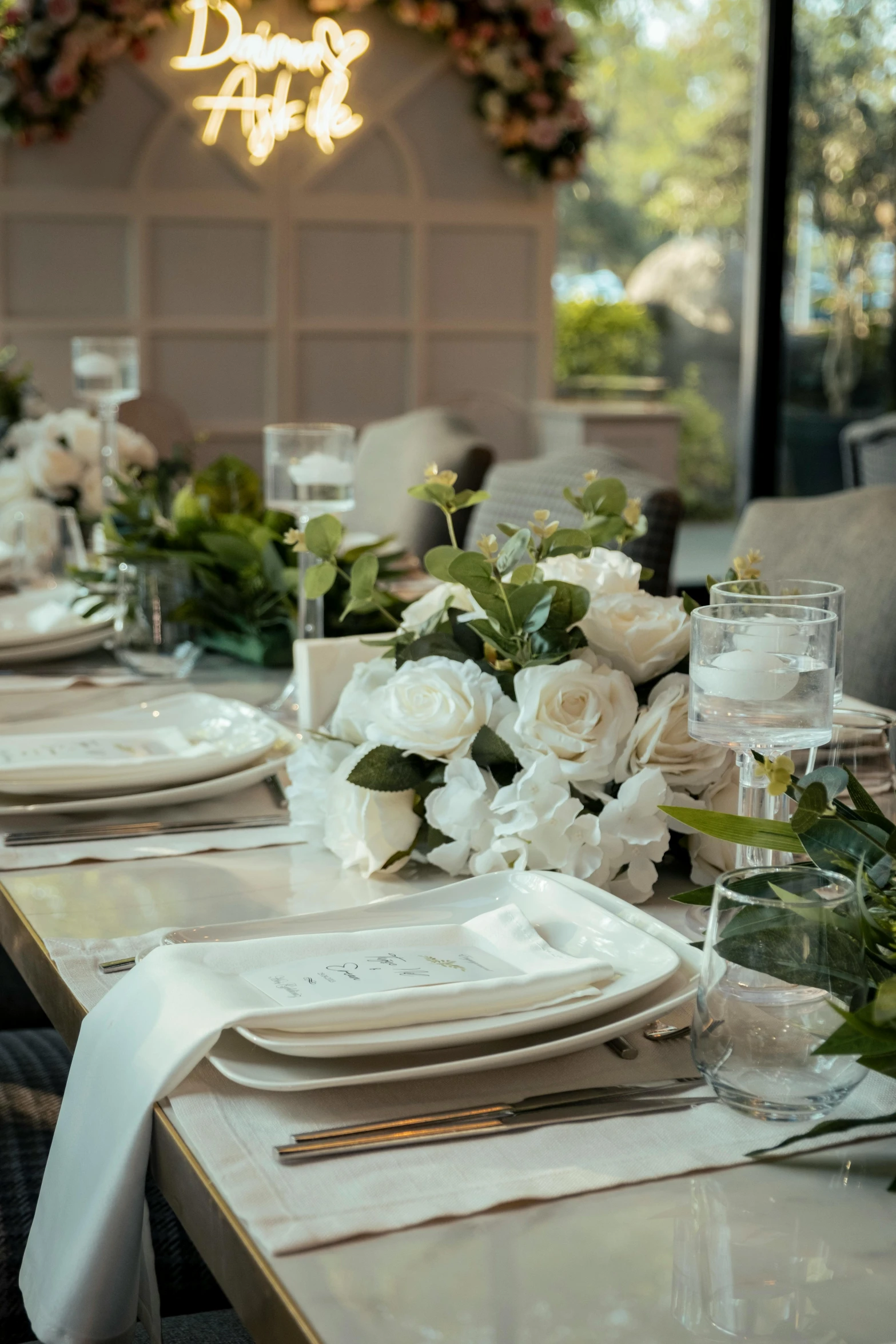 table settings with plates, wine glasses, and white roses