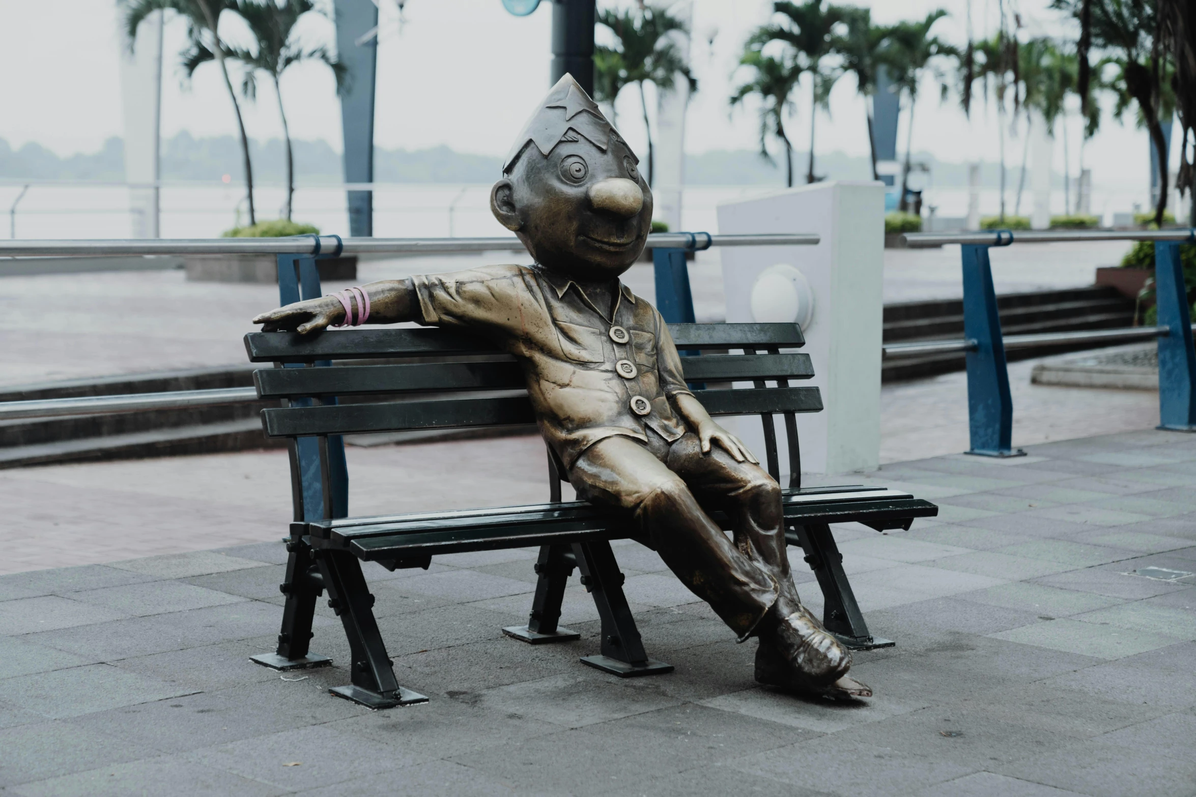 a statue of a person sitting on top of a bench