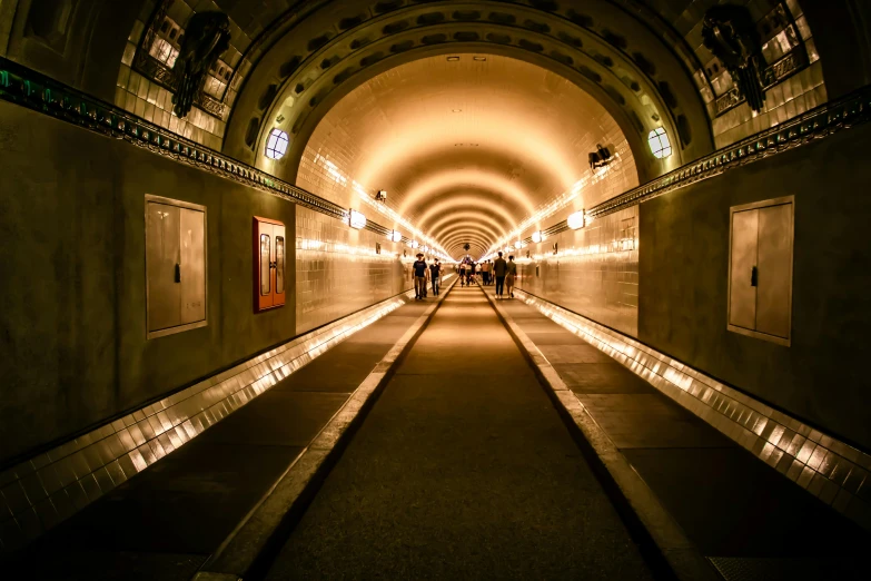 long, empty tunnel with lights at night time