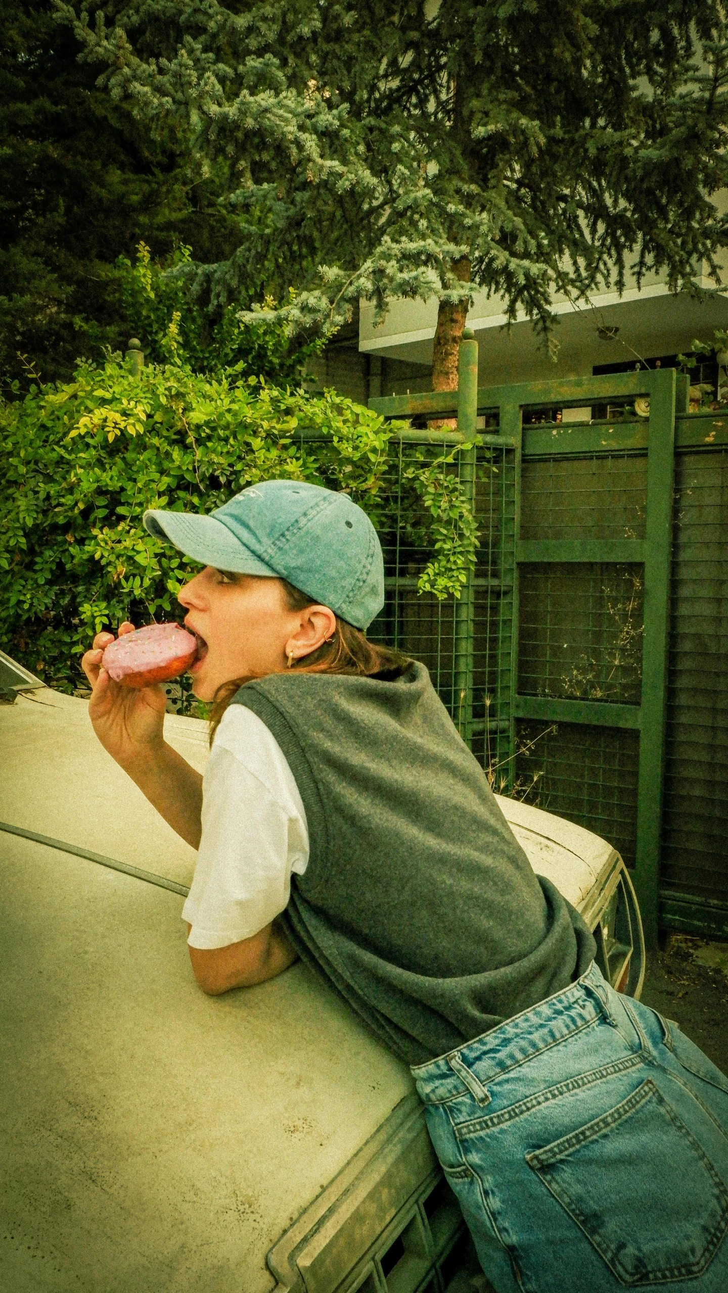 a boy drinking and sitting on top of a car