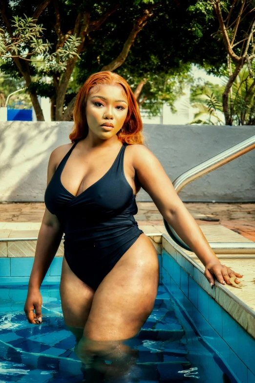 a woman is posing in an outdoor swimming pool