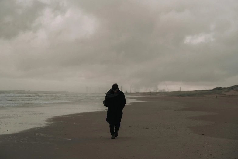 a person walking down a beach with an umbrella