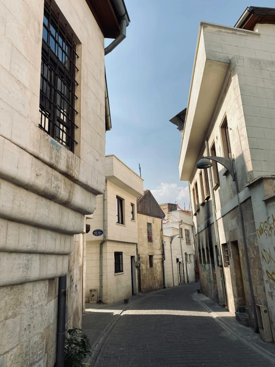 a very narrow street with a sign by a building