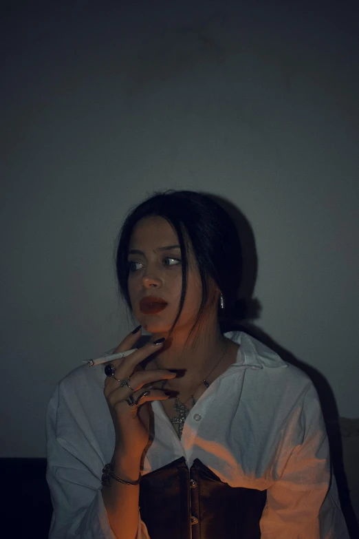 woman smoking while seated in dark room