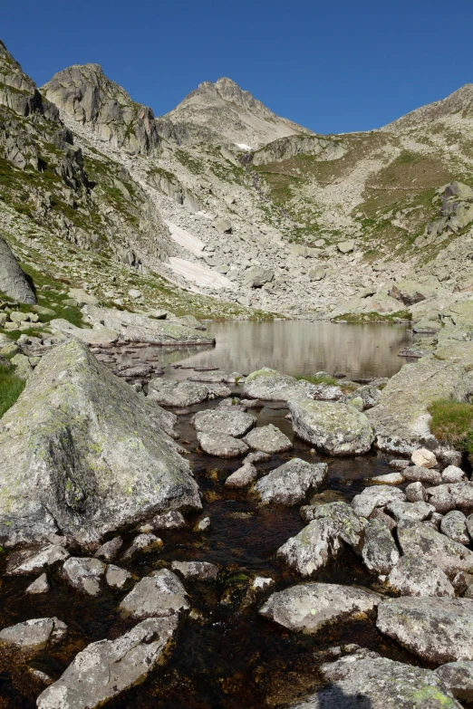 a rocky mountain with water surrounded by large rocks