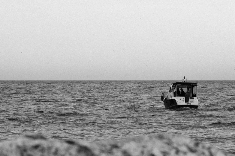 a boat traveling across the ocean on a cloudy day