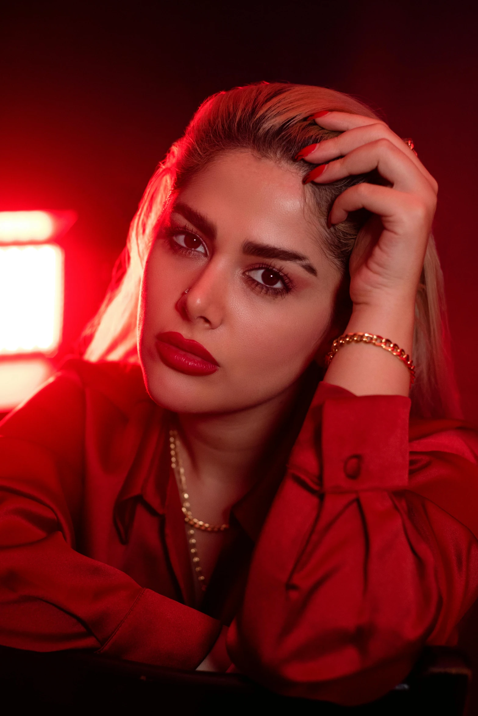 the woman is posing in a red room with a laptop