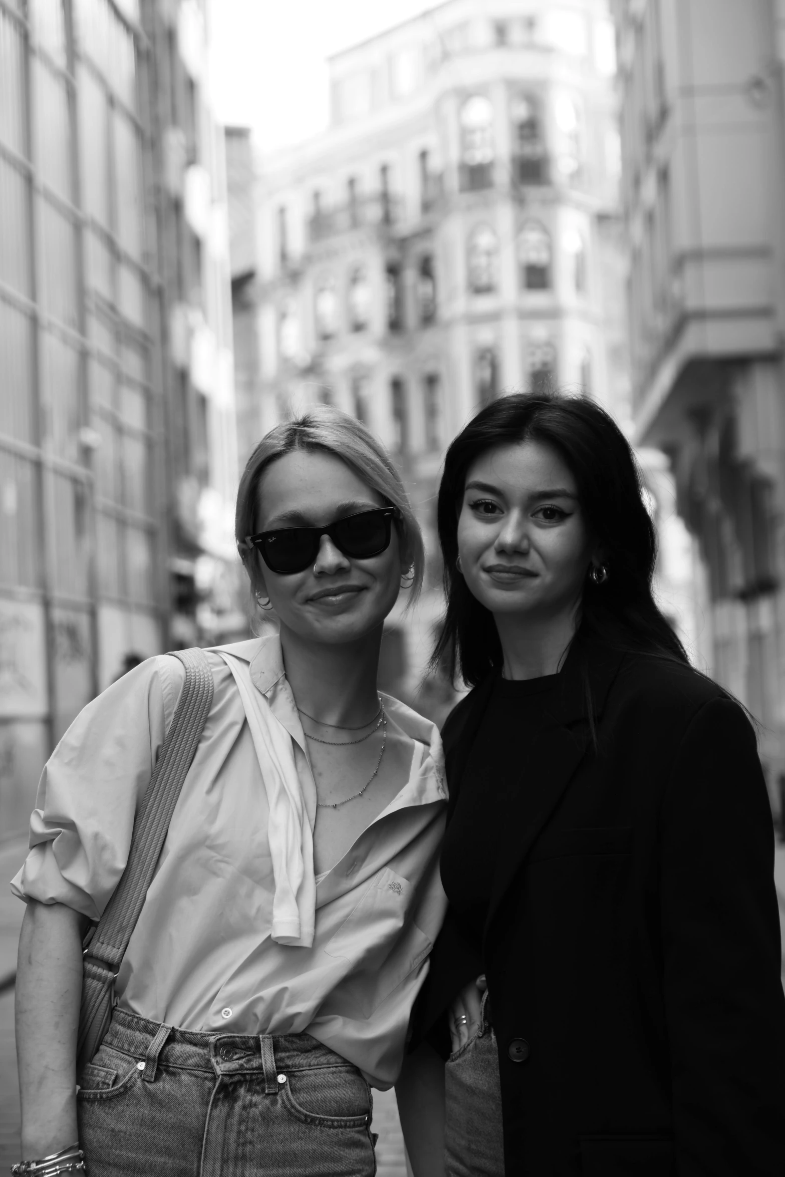 two young ladies standing in an urban street in black and white