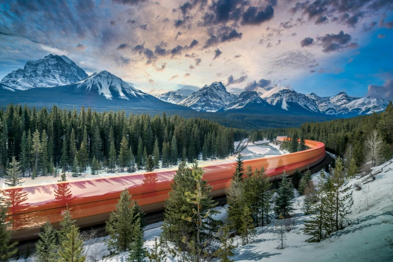 a train travels along the tracks near snow covered mountains