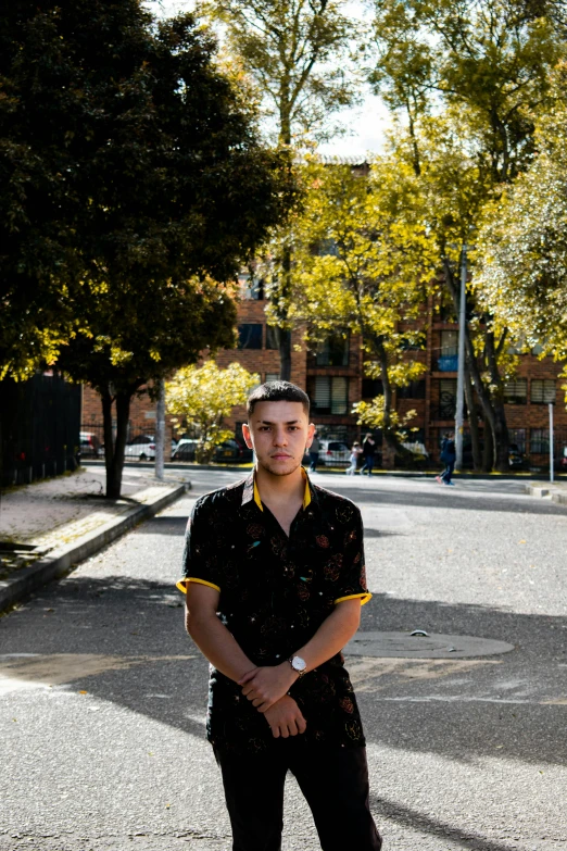 man in black shirt standing with his hands on hips